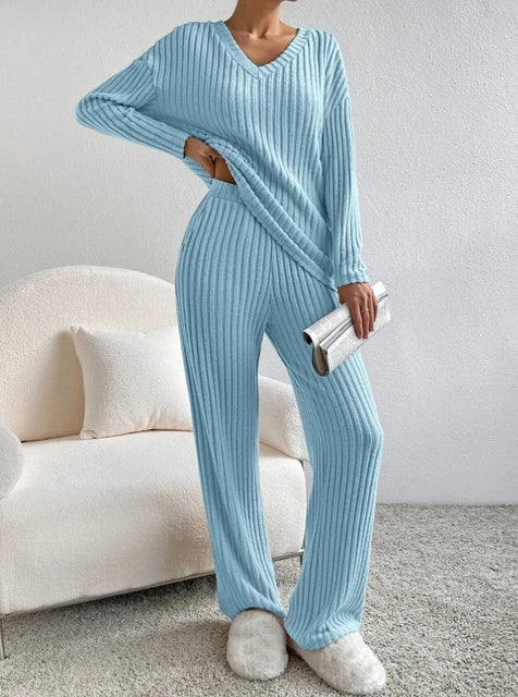 Woman wearing a matching two-piece lounge set in a neutral colour at home