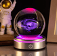 Glass ball with galaxy design on a metallic base, resembling an astronaut figure in the background.
