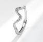 Silver ring with a wavy design and small diamonds on a light gray background
