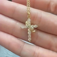 Gold cross necklace with clear stones held between fingers