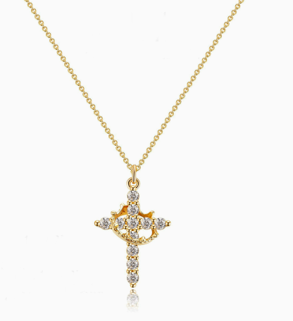 Gold cross necklace with diamond accents on a white background