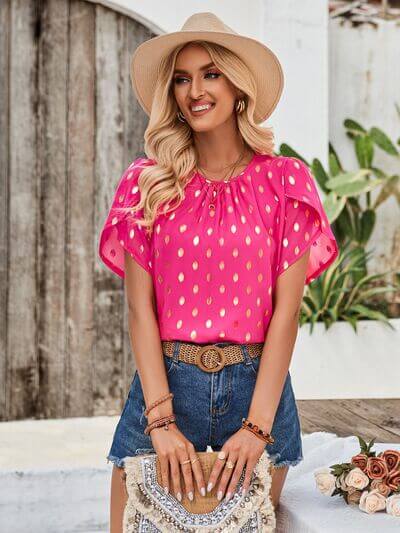 Amy Petal Sleeve Top in pink with gold brush strokes, styled with denim shorts and a hat for an elegant summer look.