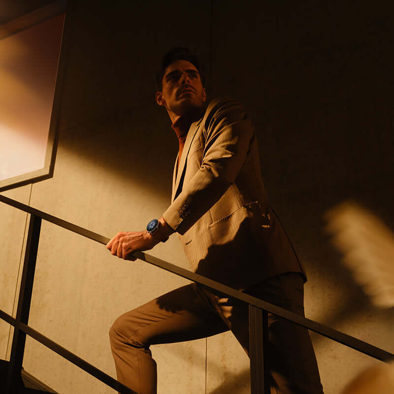 A man wearing the Amazfit GTR3 Pro Smartwatch with GPS and Health Monitor while posing on a staircase in a modern setting.