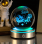Crystal ball with 3D animation of a dog and a person, illuminated by blue light, with an astronaut figure in the background.