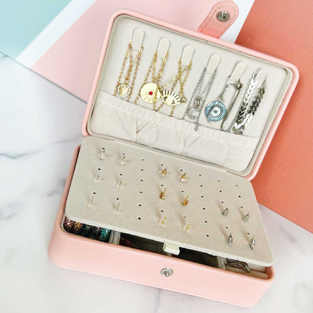 Smart Jewelry Box open showing organized earrings and necklaces inside a stylish pink case.