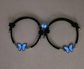 Black chokers with blue butterfly pendants on a neutral background