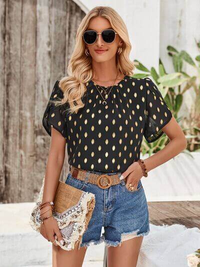 Amy Petal Sleeve Top worn by a model, featuring petal sleeves and a solid color print with gold accents.