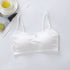 White satin camisole on a light gray surface with a cup of tea and lime slices in the background.