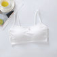 White satin camisole on a light gray surface with a cup of tea and lime slices in the background.