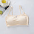 Beige bralette on a light gray surface with a cup and lime in the background