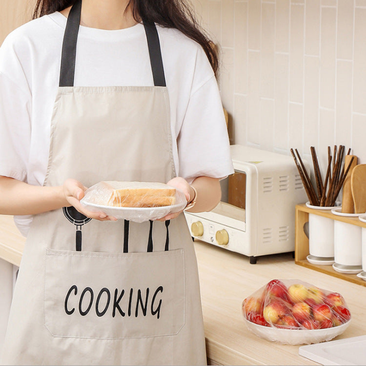 Person wearing a beige apron with &