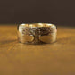 Gold ring with tree design on a brown surface