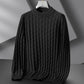 Dark gray sweater on a hanger against a neutral background