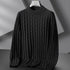 Dark gray sweater on a hanger against a neutral background