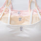 Set of three baby tank tops in pink, yellow, and white with bunny label design on a white background.