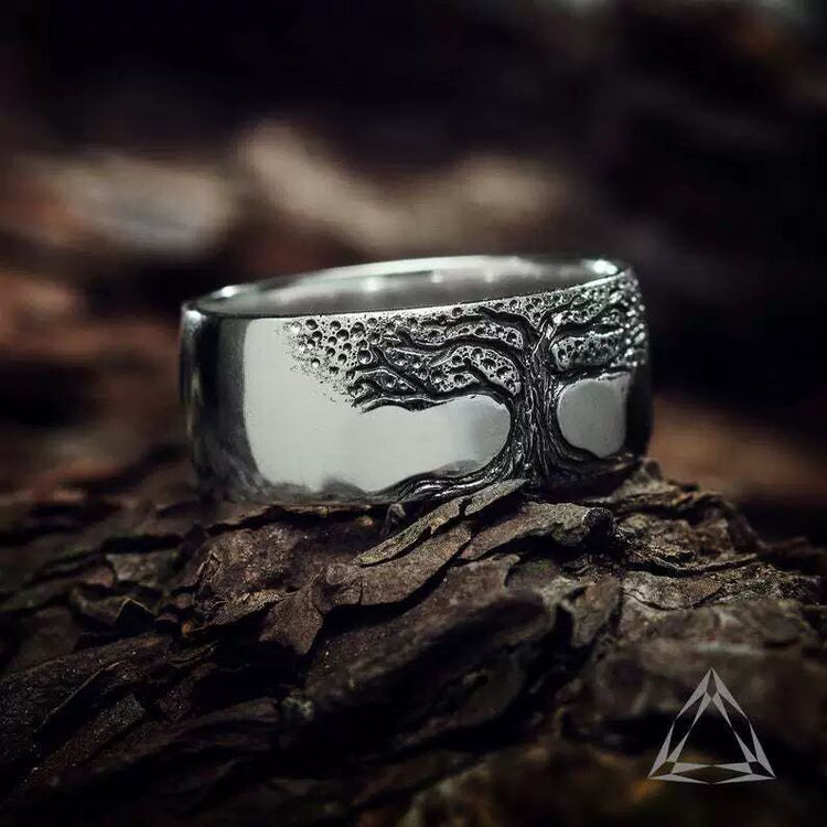 Silver tree ring on a wooden surface with a blurred natural background