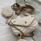 White quilted handbag with gold chain and matching coin purse on a light background
