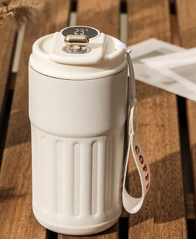 White ceramic coffee mug with a digital temperature display on a wooden surface