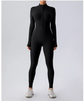 Person wearing a black full-body suit on a light gray background